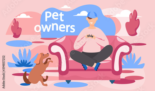 Guy plays video games, brown dog sits next to him and looks at the owner. Young man gaming with gamepad controller, holding joystick in hands. Man sitting on armchair and playing a computer game