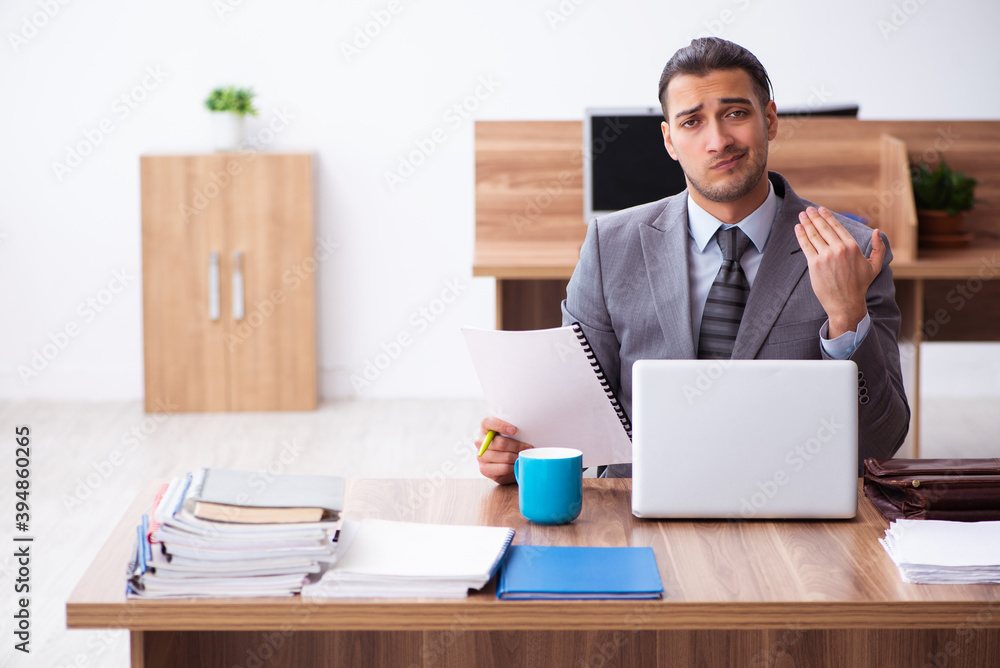 Young male employee unhappy with excessive work Young male employee unhappy with excessive work