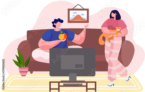 Man and woman young family pet owners at home with a cat, girl holding an animal in her arms, hugging with him. Guy sitting on the sofa front of the TV holding an apple. Owner with her tender kitty