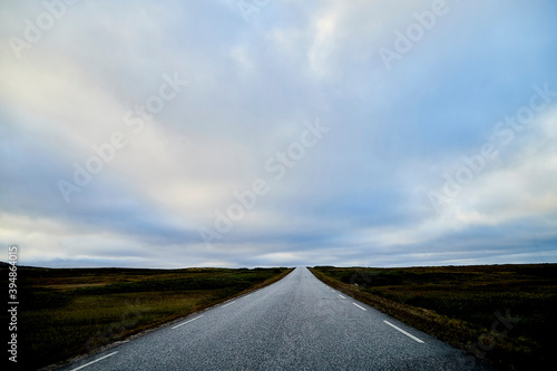 Landscape with road in tundra in Norway at cloudy evening