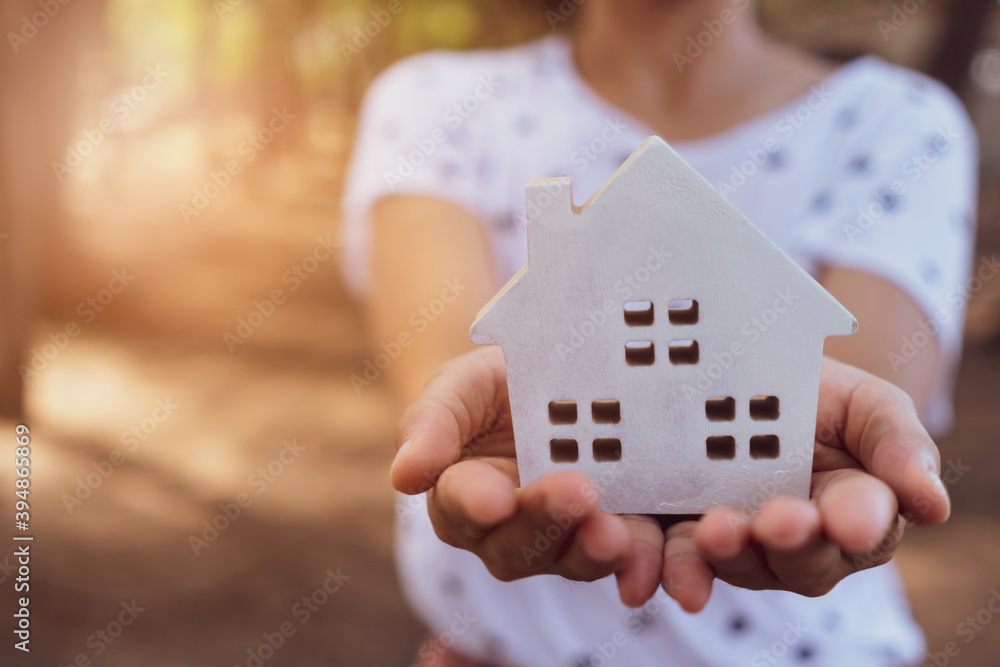 Copyspace model of a little house that woman holds it background. Deam life have own house property for living or investment. Copyspace model of a little house that woman holds it background. Deam life have own house property for living or investment.