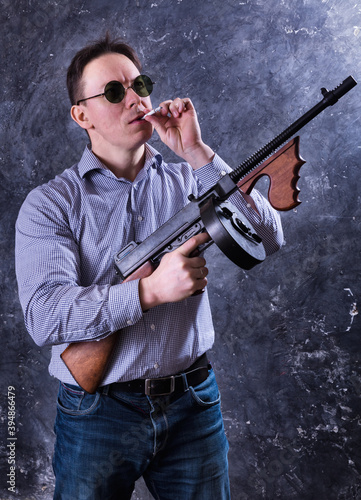 Mature man in sunglasses with tommy gun © idea_studio