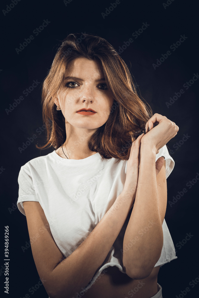 Studio portrait of young beautiful woman dressed in a white jeans and t-shirt Studio portrait of young beautiful woman dressed in a white jeans and t-shirt