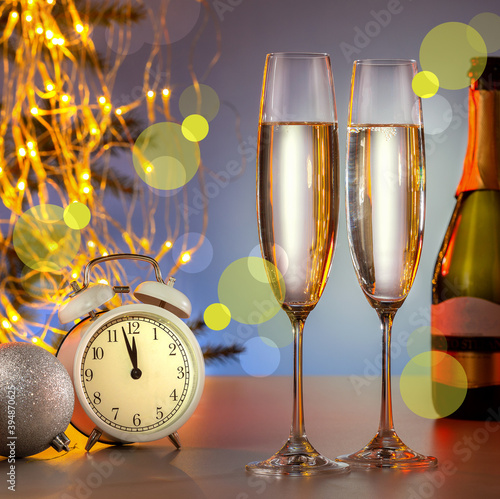 Glasses of champagne, vintage clock and christmas decorations. New Year card.