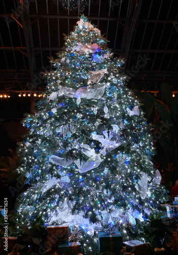 A beautifully decorated Christmas tree with blue and silver ornaments
