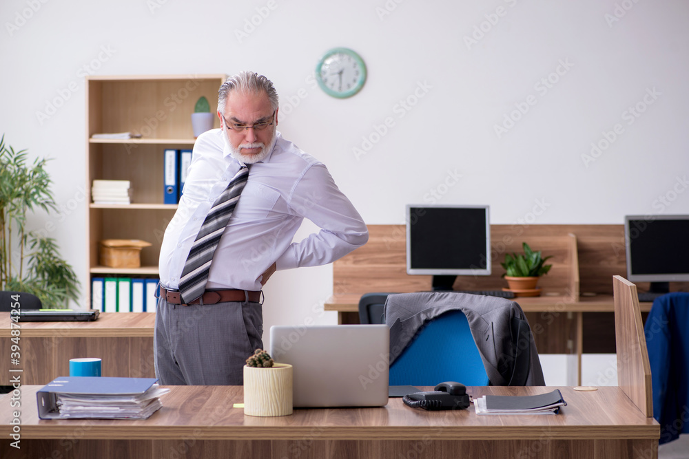 Old male employee suffering from radiculitis at workplace Old male employee suffering from radiculitis at workplace
