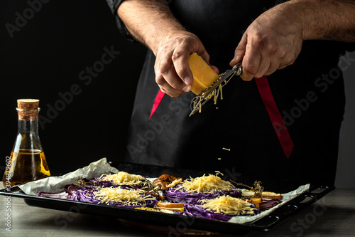 Foto Chef cooking vegetables dish of red cabbage baked with nuts, quince and apples,