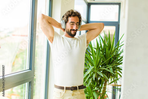 young bearded man listening music with his headphones photo