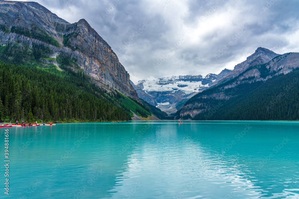 Canoeing on Lake Louise in summer day. Tourists enjoy leisure water activities on the turquoise color lake in Banff National Park, Alberta, Canada. Canoeing on Lake Louise in summer day. Tourists enjoy leisure water activities on the turquoise color lake in Banff National Park, Alberta, Canada.