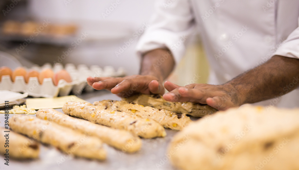chef kneading dough on table in bakery