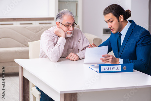 Young male lawyer visiting old man in testament concept