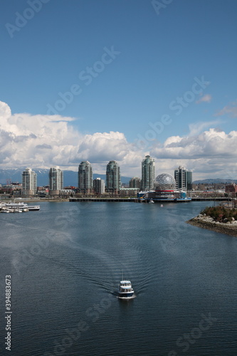 View of Vancouver False Creek waterfront skyline with snow mountain during springtime Seen from Cambie Bridge in the downtown of Vancouver, British Columbia, Canada.