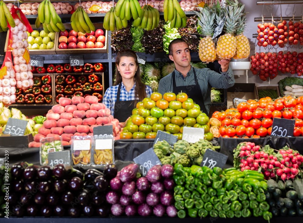 Male and female shop assistants in vegetable shop