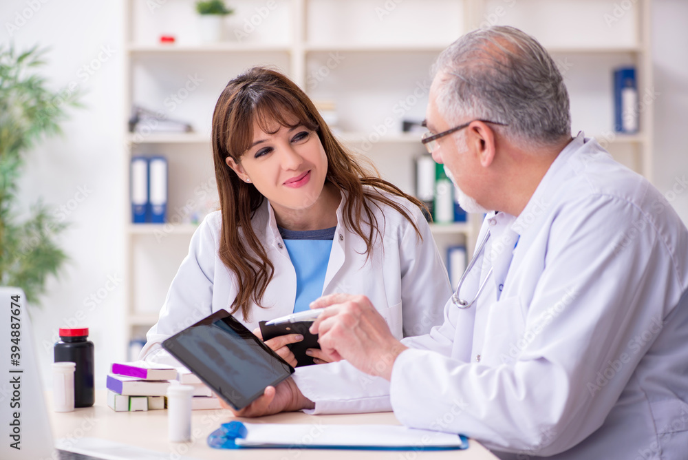 Fototapeta premium Old male doctor radiologist and his young female assistant in th