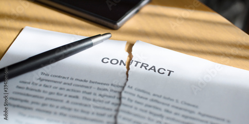Foto A torn contract on the table.  Torn document on the desk.