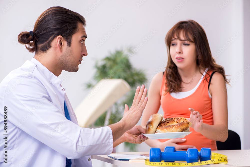 Fototapeta premium Pregnant woman visiting male doctor gynecologist