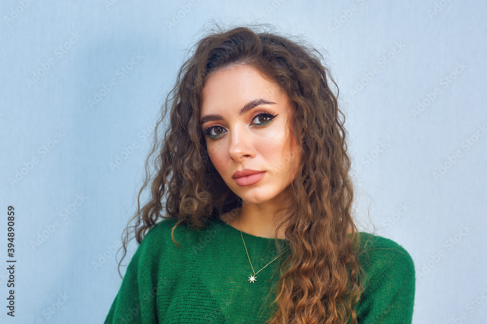 Beautiful model with curly hair. Portrait of a beautiful girl on a light background Beautiful model with curly hair. Portrait of a beautiful girl on a light background
