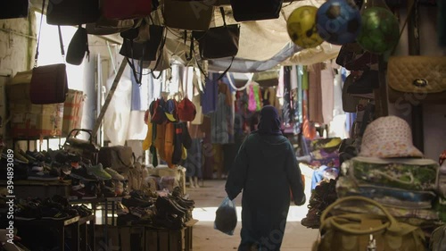 Muslmim women is walking in a typical souk (market) in Morocco, lot of colors.
