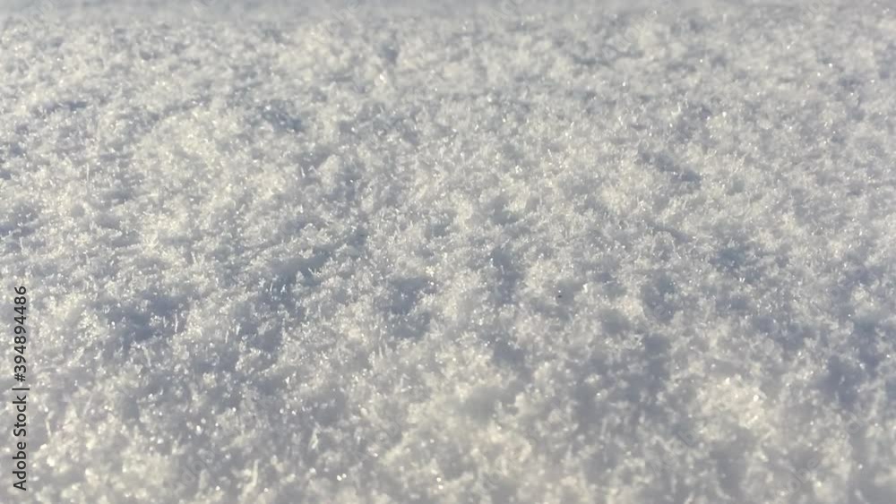 Awesome winter scene. Snow texture close-up. Micro texture of the snow surface. Ice crystals and snowflakes shine and sparkle. Rustic field in the snow. Pouring warm light from the Sun. Awesome winter scene. Snow texture close-up. Micro texture of the snow surface. Ice crystals and snowflakes shine and sparkle. Rustic field in the snow. Pouring warm light from the Sun.