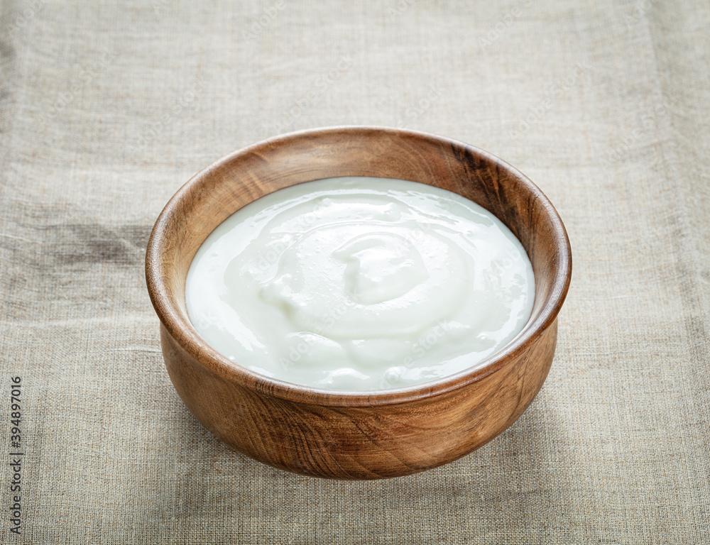 cream sour in wooden bowl on a canvas cream sour in wooden bowl on a canvas