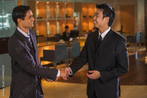Businessmen shaking hands in bar