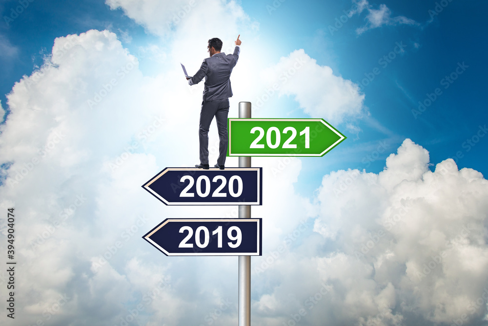 Road sign and businessman with 2020 and 2021