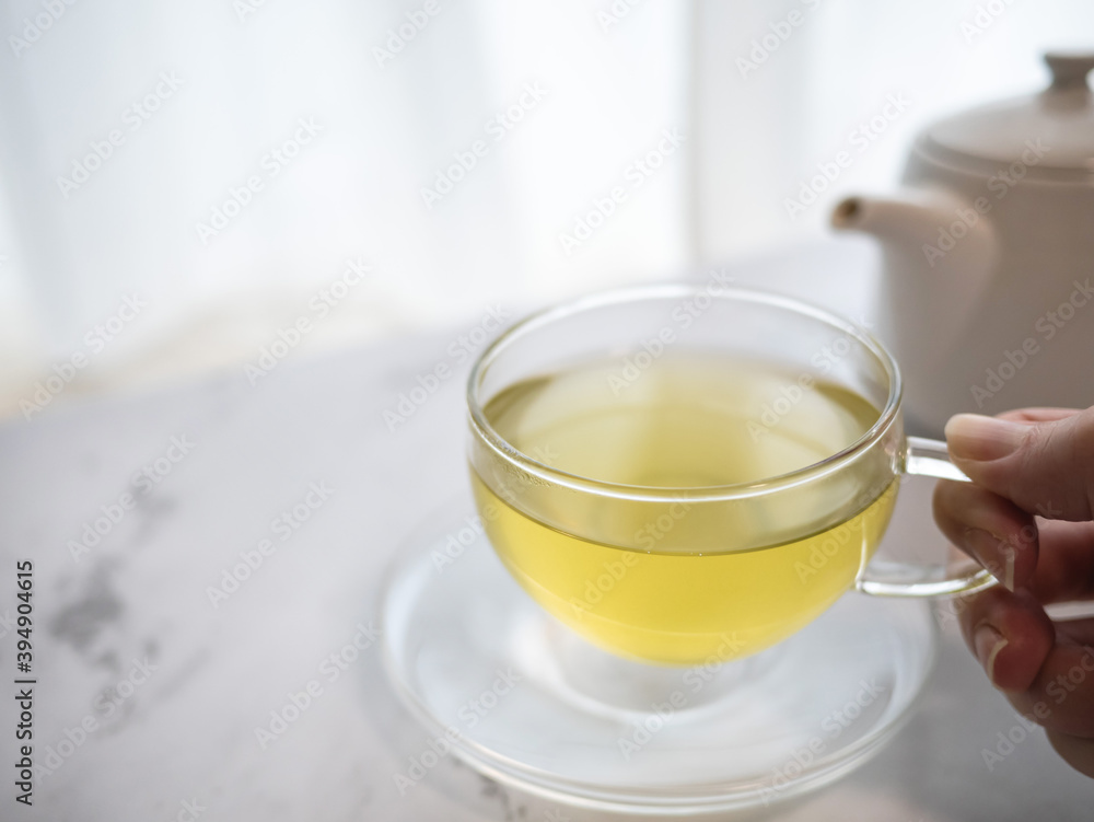 透明耐熱グラスに急須で注がれた緑茶・日本茶を家で飲む様子。