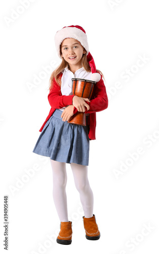 Cute little girl in Santa hat and with drum on white background