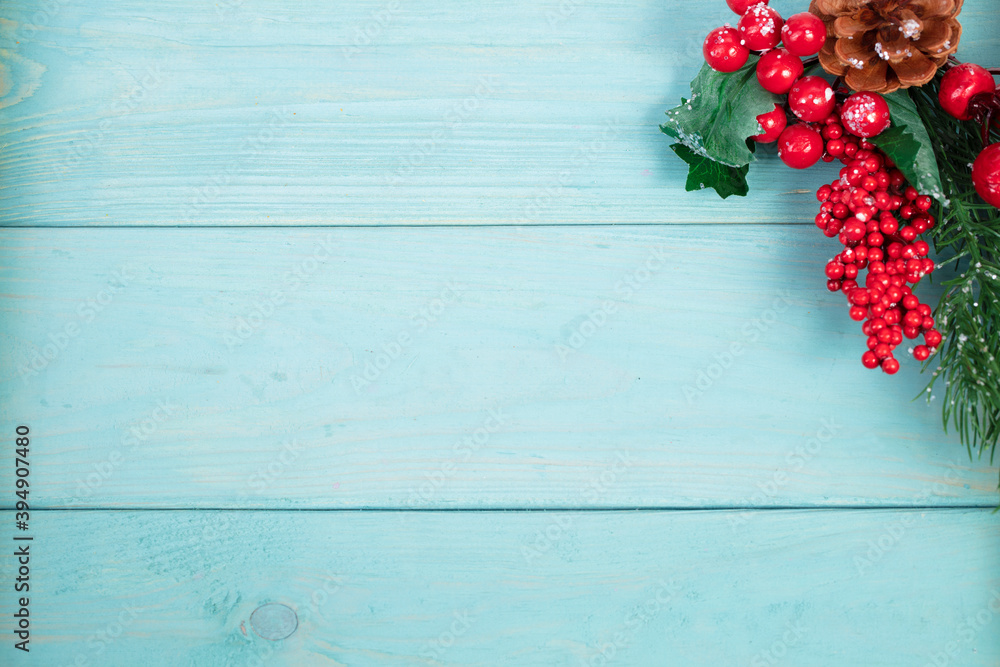 On a turquoise wood background, a decoration of a spruce branch and cones. Christmas background. On a turquoise wood background, a decoration of a spruce branch and cones. Christmas background.