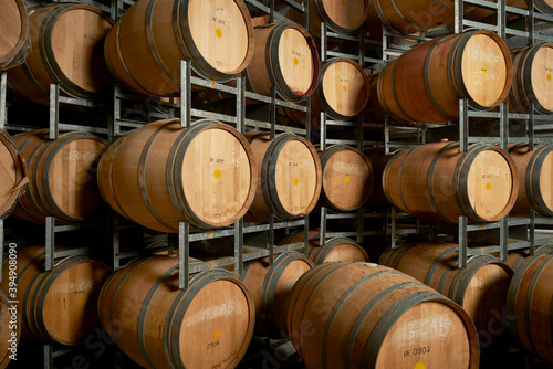 Rows of wine barrels on storage racks in cellar for aging wine photo