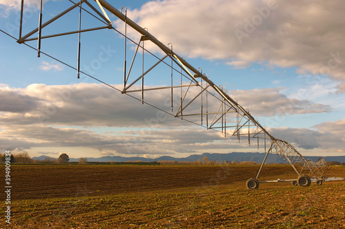 Moveable Irrigation boom sprinkler system in large ploughed field