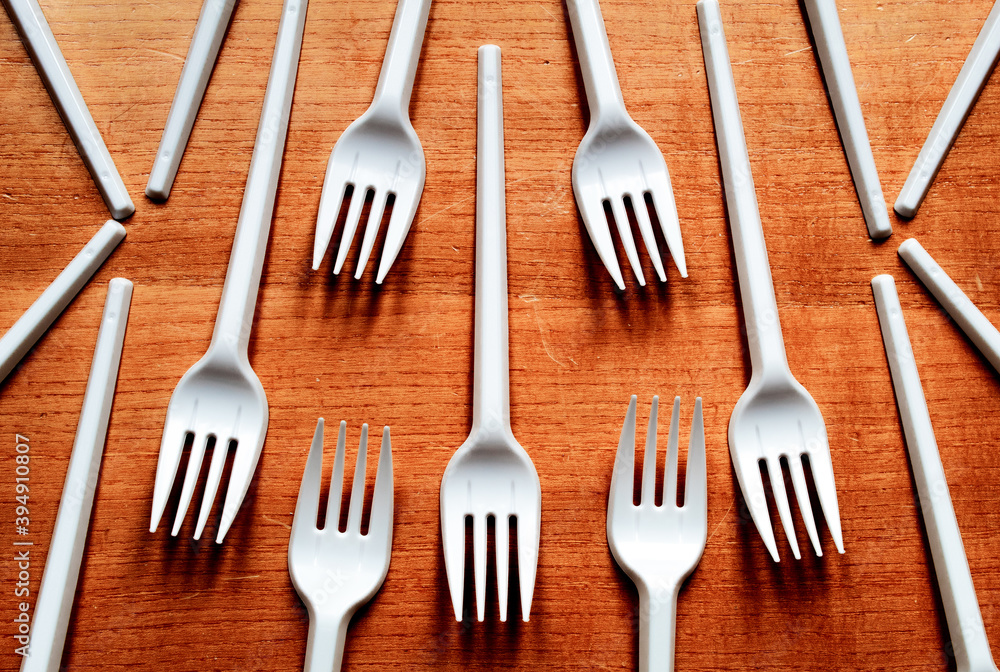 Some plastic forks placed on a wooden table. Some plastic forks placed on a wooden table.