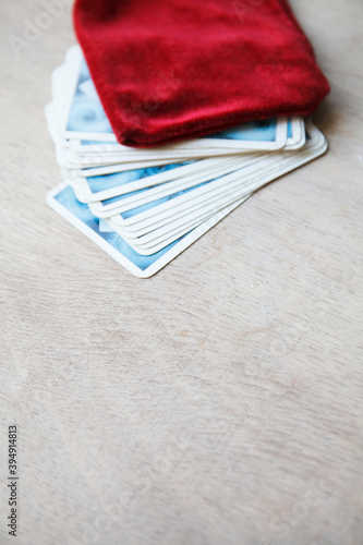 Tarot card deck with red velvet bag for fortune-telling on old wooden table. Selective focus. Copy space
