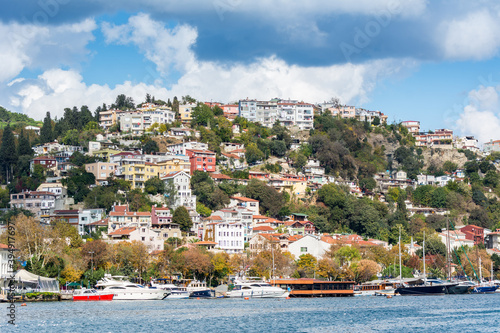 Modern buildings and ancient architecture along the Bosphorus strait in Istanbul Turkey from ferry on a sunny day with background of cloudy sky