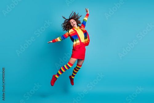 Full body photo of young attractive curly hair girl wear skirt crazy fun carefree jump fly isolated over blue color background