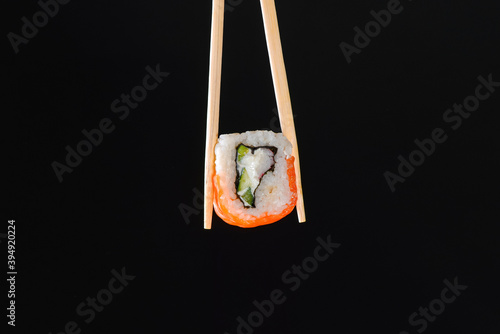 Vibrant sushi set, creative idea concept. Sushi in chopsticks, California or Philadelphia sushi rolls.