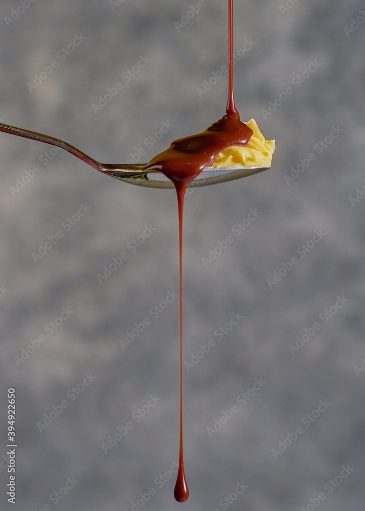 Chocolate milk dripping on spoon of butter Chocolate milk dripping on spoon of butter