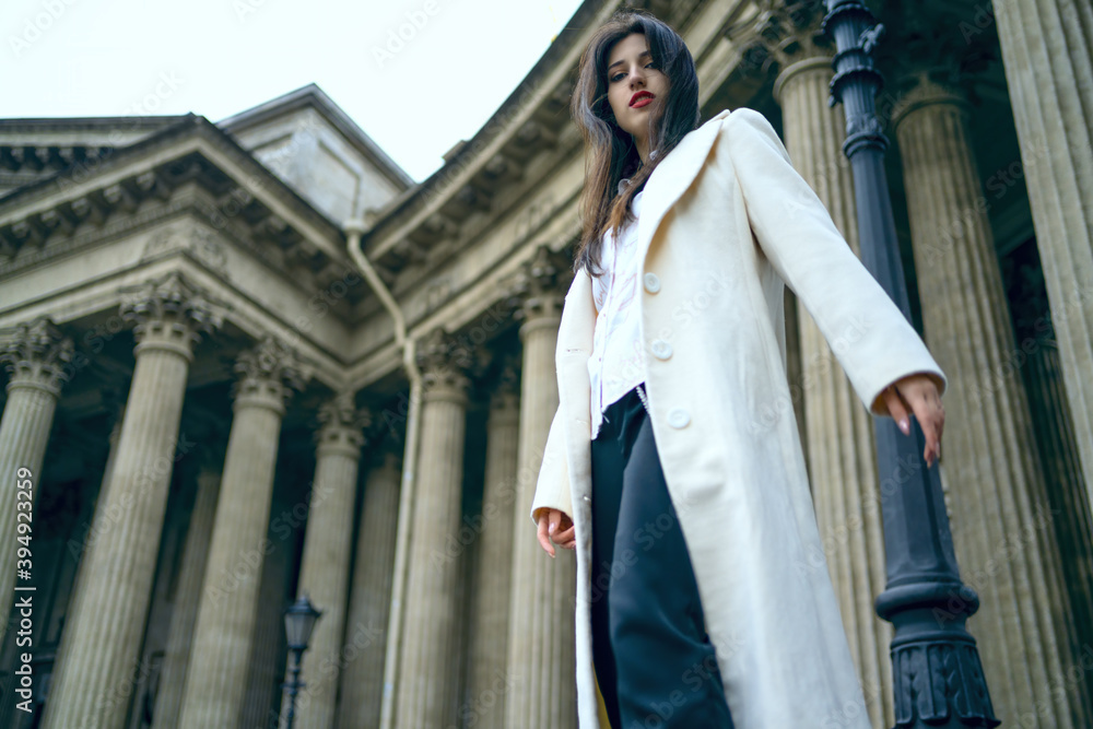 Naklejka premium Beautiful model girl woman on a background of old columns. Attractions behind the old cathedral