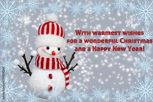 Greeting card Happy New Year 2021. Beautiful christmas snowman toy on the snow with red sparkling text "With warmest wishes for a wonderful Christmas and a Happy New Year!"  Israel, Haifa, 24.11.2020