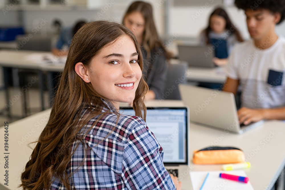 Happy smiling college girl studying on laptop Happy smiling college girl studying on laptop