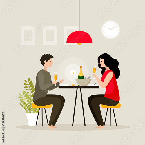 Young beautiful couple having dinner at home by candlelight drinking champagne. Romantic dinner at home.