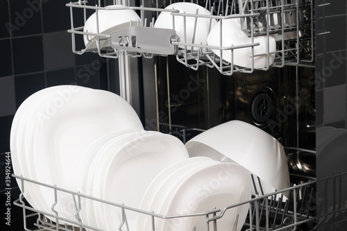 white clean plates in the dishwasher, background, side view