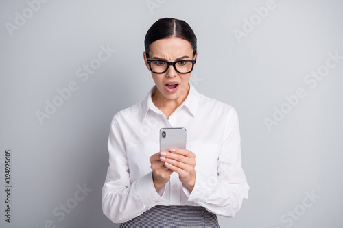 Photo of speechless business lady hold smartphone open mouth staring wear glasses white shirt isolated grey color background