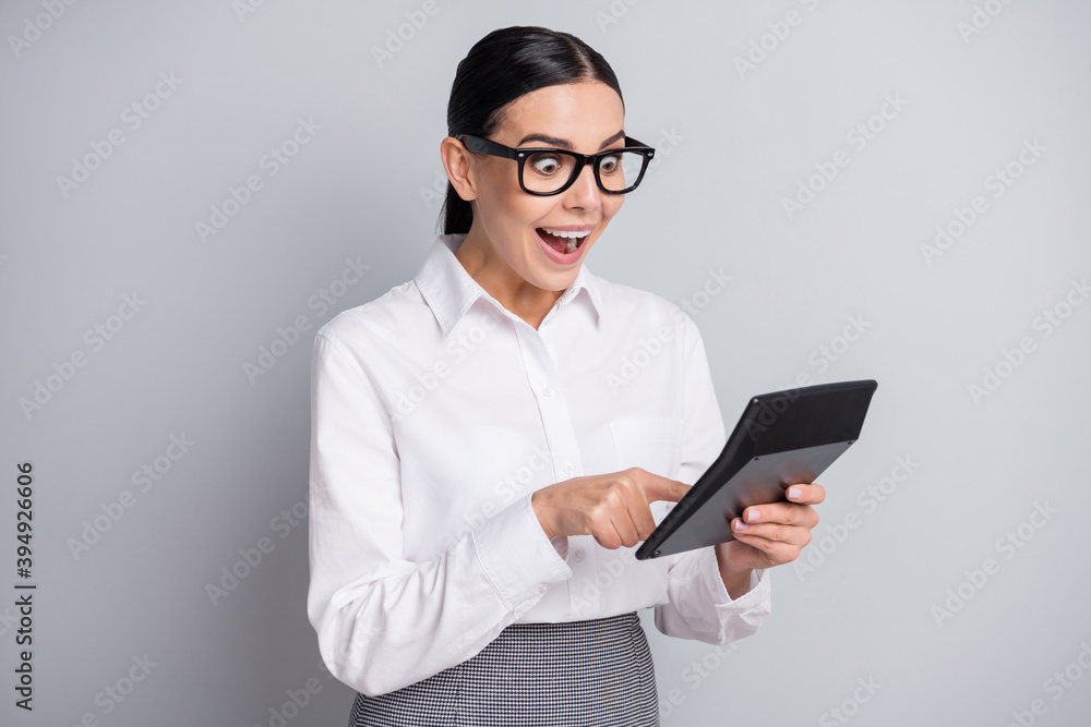 Photo of young shocked accountant hold calculator open mouth wear eyeglasses white shirt isolated grey color background Photo of young shocked accountant hold calculator open mouth wear eyeglasses white shirt isolated grey color background