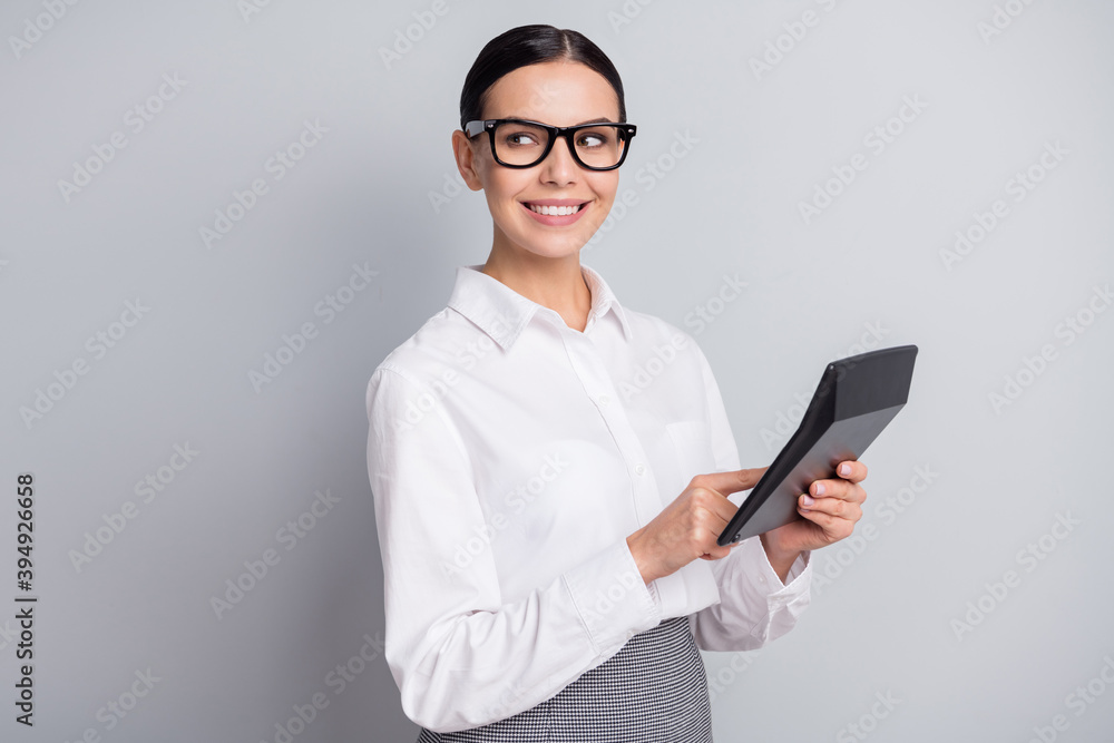 Photo of young manager hold calculator look empty space wear specs white shirt isolated grey color background