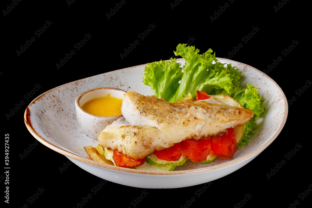 Halibut steak with vegetables isolated on black Halibut steak with vegetables isolated on black