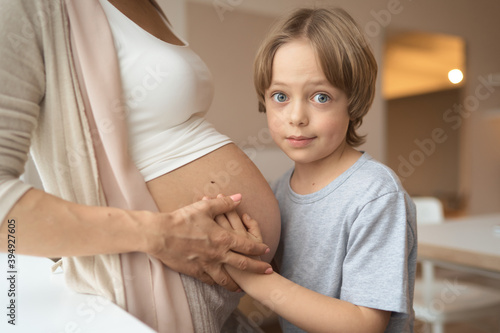 little boy listening to mom pregnant belly. High quality photo