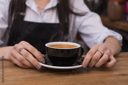 Barista girl gives delicious, aromatic and invigorating Americano coffee