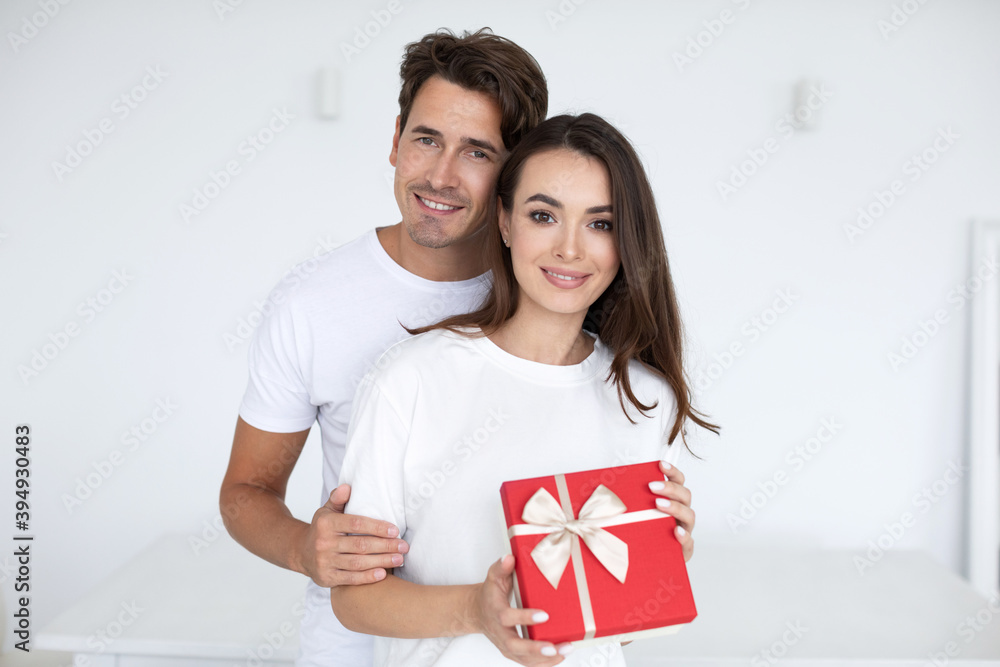 Portrait of a smiling young couple with gift box at home. Portrait of a smiling young couple with gift box at home.