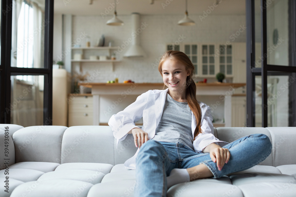 Young smiling woman sitting on sofa at home. Young smiling woman sitting on sofa at home.